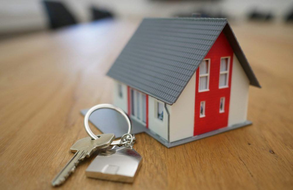 white and red wooden house miniature on brown table